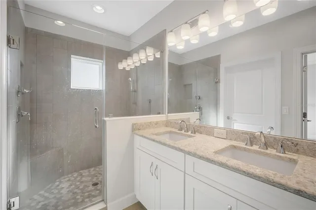 a bathroom with a sink double vanity and a shower