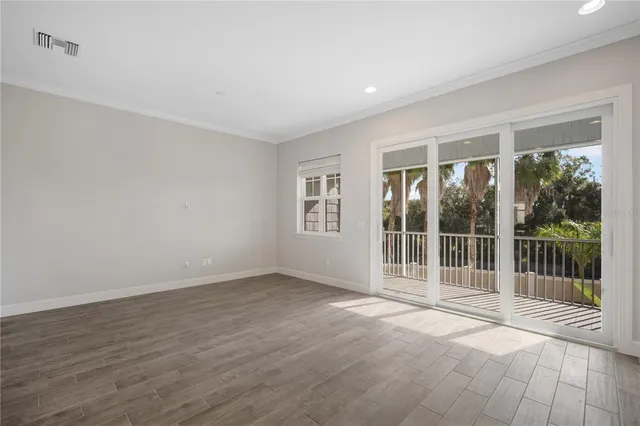 a view of an empty room with wooden floor and garden