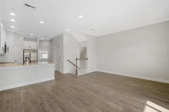 a view of empty room with wooden floor and window