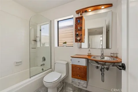 a bathroom with a toilet a sink a mirror a bathtub and shower