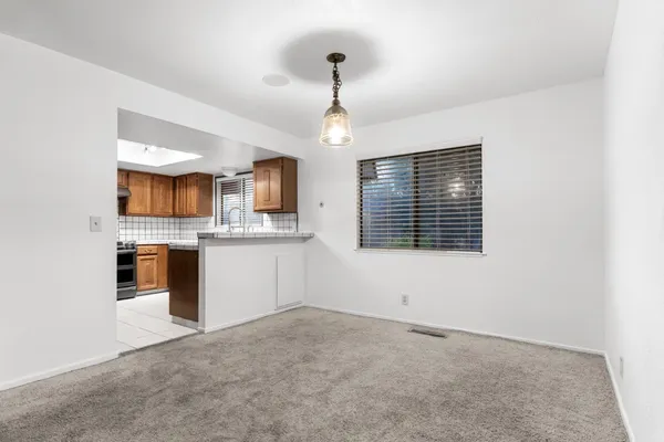 a view of an empty room with a kitchen