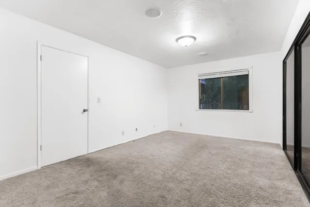 an empty room with windows and closet