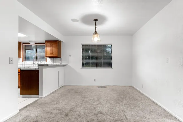 a view of kitchen with granite countertop cabinets and chandelier