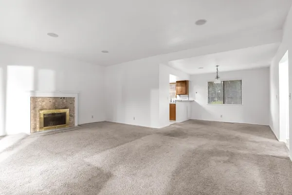 a view of empty room with a fireplace and windows