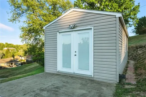 a front view of house with yard and trees in the background