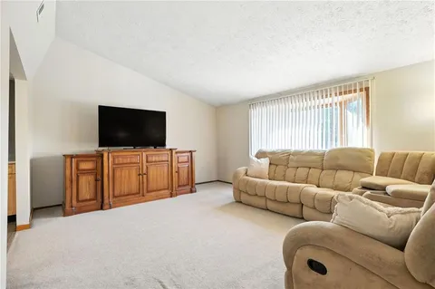 a living room with furniture a dining table and a large window