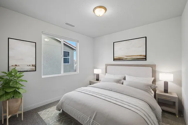 a bedroom with a bed and a potted plant