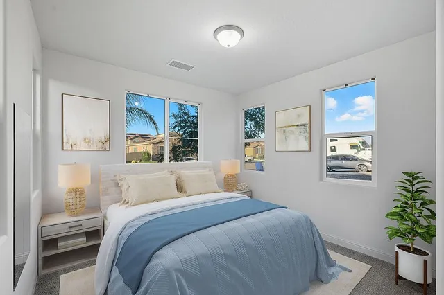 a bedroom with a large bed and a potted plant
