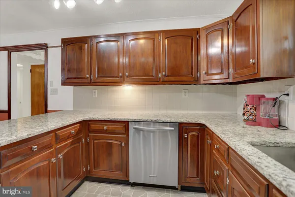 a kitchen with granite countertop stainless steel appliances and wooden cabinets