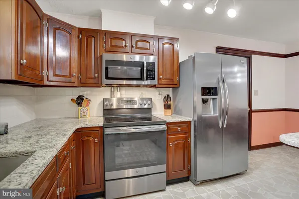 a kitchen with stainless steel appliances granite countertop a refrigerator and a stove
