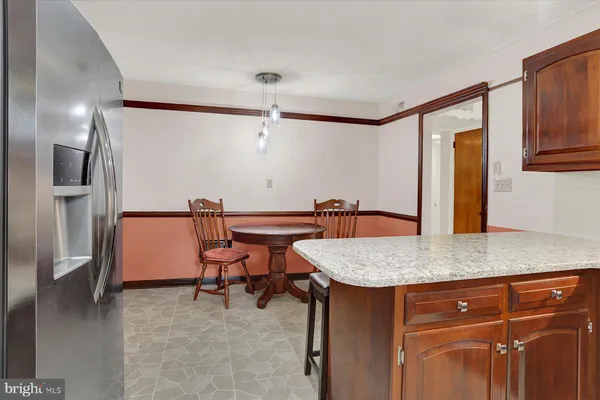 a kitchen with kitchen island granite countertop a sink a counter top space appliances and cabinets