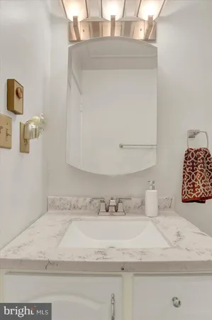 a bathroom with a sink a light fixture and a mirror