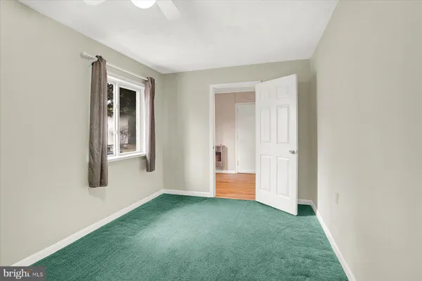 a view of hallway with walk in closet and wooden floor