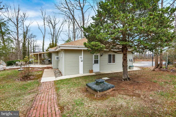 a view of a backyard with table and chairs under a large tree