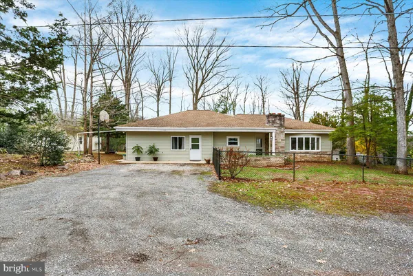 a view of a house with a yard and large tree