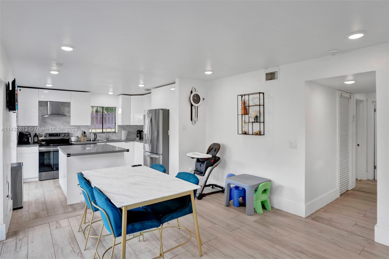 20429 Northeast 10th Ct Road Miami, FL 33179 - Photo 11 of 42 a kitchen with a refrigerator a stove top oven a sink and wooden floor