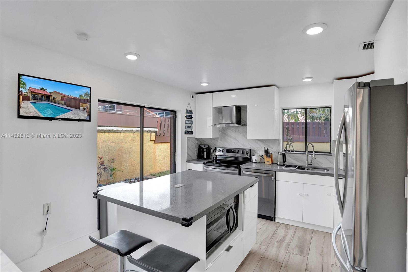 20429 Northeast 10th Ct Road Miami, FL 33179 - Photo 13 of 42 a kitchen with kitchen island a counter top space a sink stainless steel appliances and cabinets