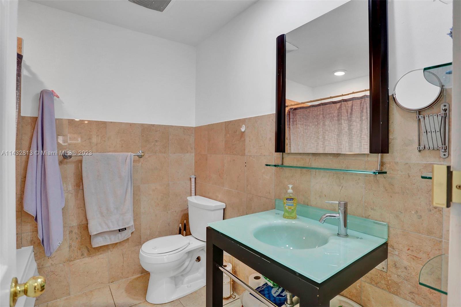20429 Northeast 10th Ct Road Miami, FL 33179 - Photo 21 of 42 a bathroom with a sink toilet and mirror