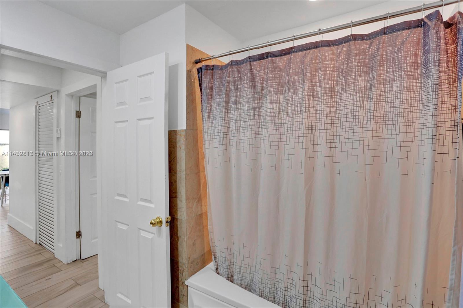 20429 Northeast 10th Ct Road Miami, FL 33179 - Photo 22 of 42 a bathroom with a shower and a curtain