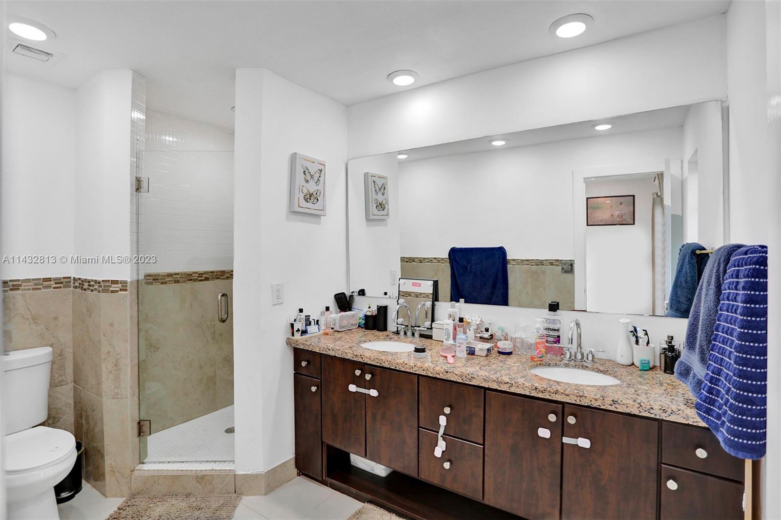20429 Northeast 10th Ct Road Miami, FL 33179 - Photo 26 of 42 a spacious bathroom with a granite countertop sink mirror and toilet