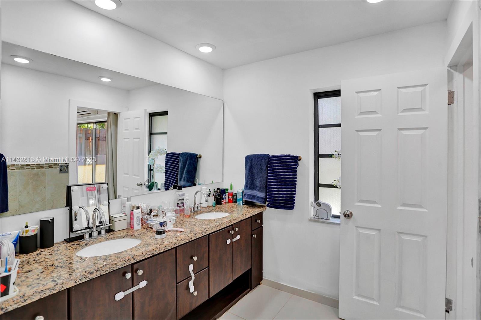 20429 Northeast 10th Ct Road Miami, FL 33179 - Photo 27 of 42 a spacious bathroom with double vanity and a mirror