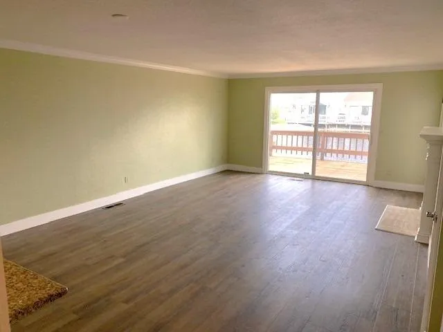 wooden floor in an empty room with a window