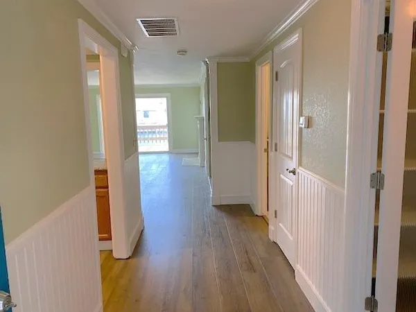 a view of a hallway with wooden floor