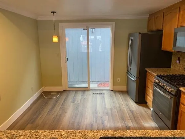 a view of a kitchen with wooden floor and a refrigerator