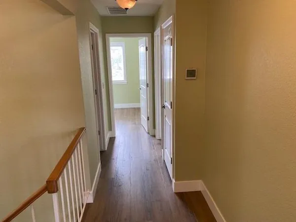 a view of a hallway with wooden floor
