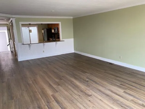 a view of a room with wooden floor and small window