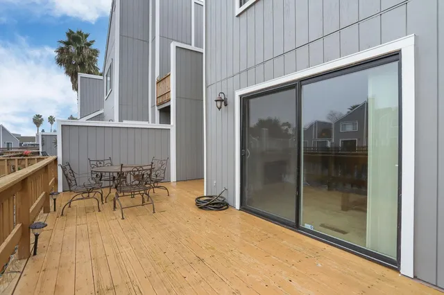 a view of a patio with table and chairs with wooden floor and fence