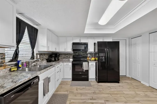 a kitchen with stainless steel appliances granite countertop a refrigerator and a stove top oven
