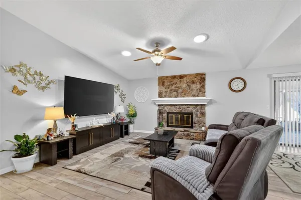 a living room with furniture a fireplace and a flat screen tv
