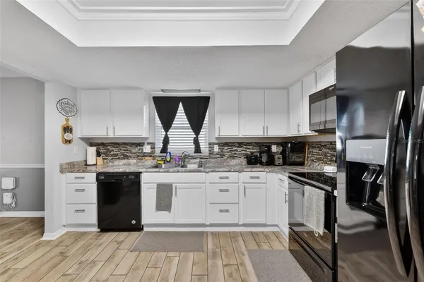 a kitchen with stainless steel appliances granite countertop a stove top oven a sink dishwasher and a refrigerator