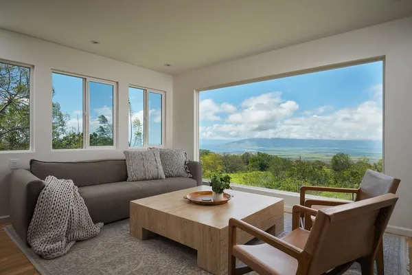 a living room with furniture and a floor to ceiling window