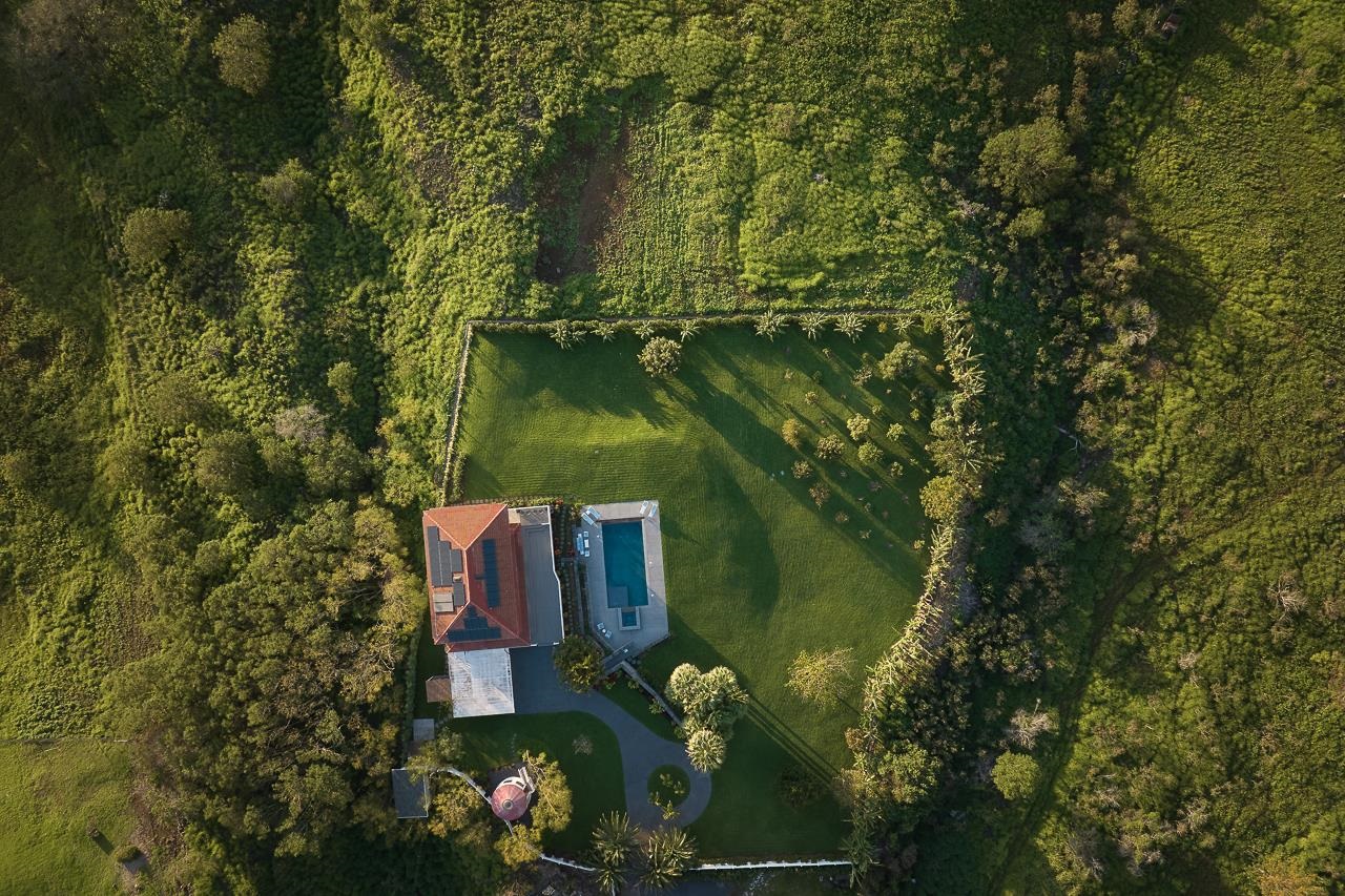 Undisclosed Address Kula, HI 96790 - Photo 41 of 50 an aerial view of a house with a yard lake and trees all around
