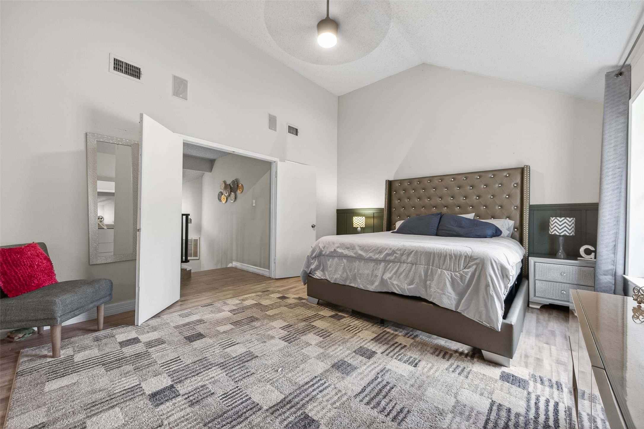 18446 North Willow Bluff Road Katy, TX 77449 - Photo 18 of 33 This spacious bedroom features a high ceiling, modern design, and a large bed with an elegant headboard. It includes ample natural light, a cozy seating area, and stylish decor, creating a comfortable and inviting atmosphere.