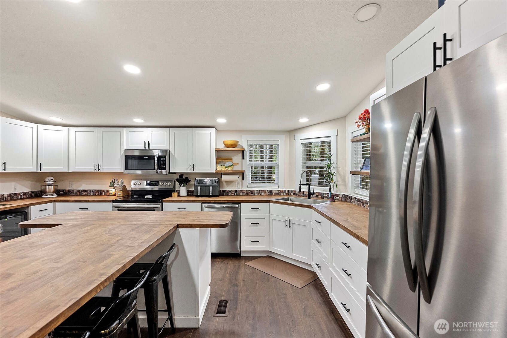 721 East McMickin Road Shelton, WA 98584 - Photo 10 of 38 a kitchen with stainless steel appliances granite countertop a refrigerator a stove top oven a sink dishwasher and white cabinets with wooden floor