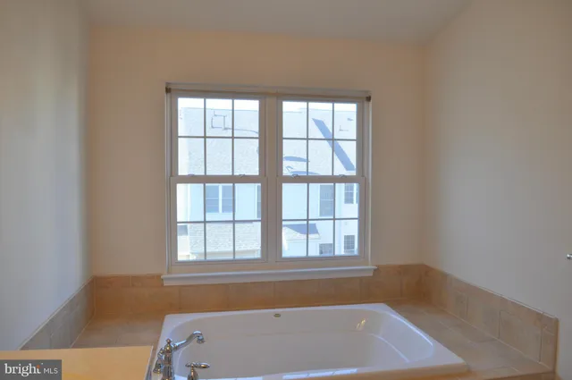 a bathroom with a bathtub and next to a window
