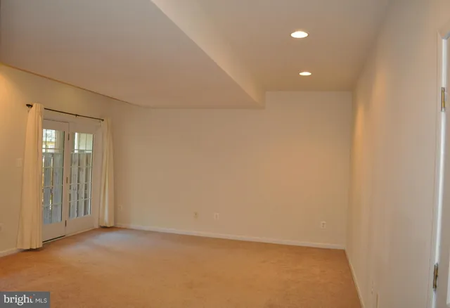 an empty room with windows and entrance to other room