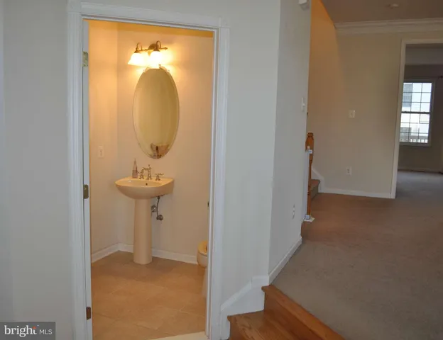 a view of a hallway with wooden floor and a door