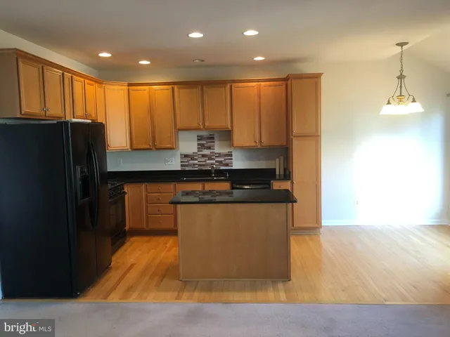 a kitchen with stainless steel appliances granite countertop a refrigerator a sink a stove a microwave and island