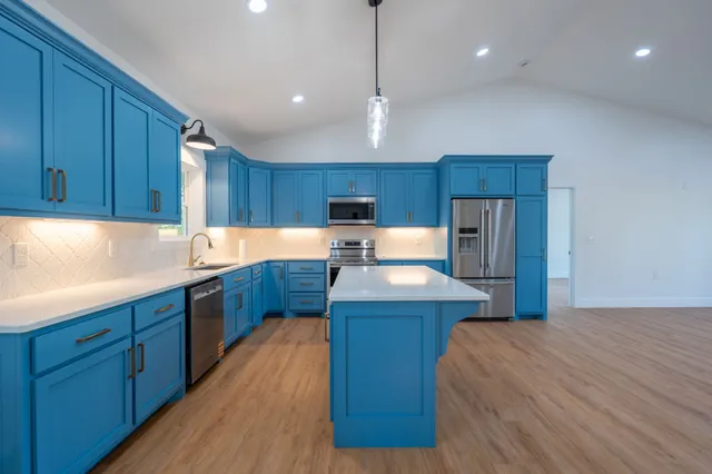 a kitchen with wooden floors and wooden cabinets