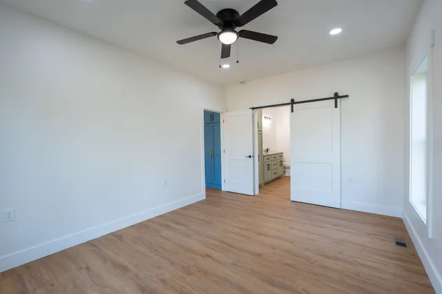 a view of an empty room with a ceiling fan window and a ceiling fan