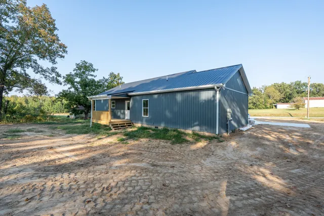 a view of a house with backyard and trees