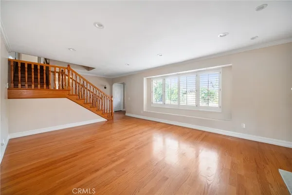 a kitchen with white cabinets and wooden floor