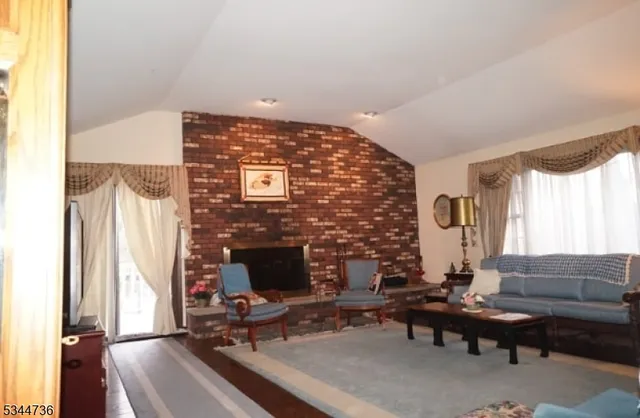 a living room with furniture a fireplace and a large window
