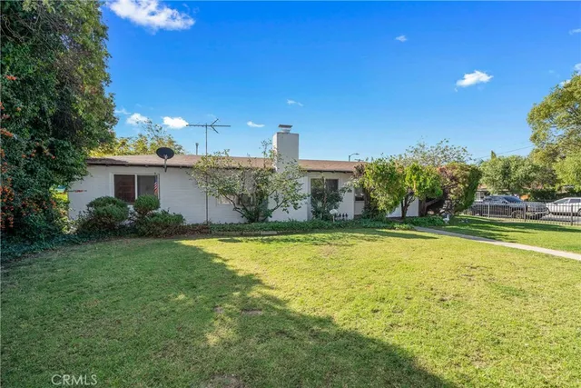 a view of a house with swimming pool and a yard