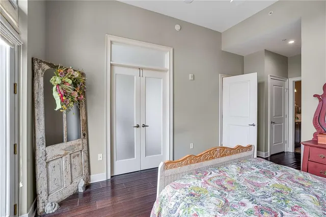 a bedroom with a bed and a flat tv screen on the dresser