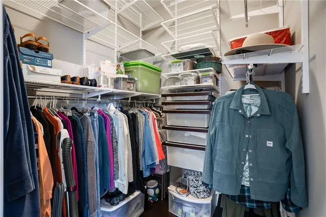 a view of walk in closet with clothes and shoes